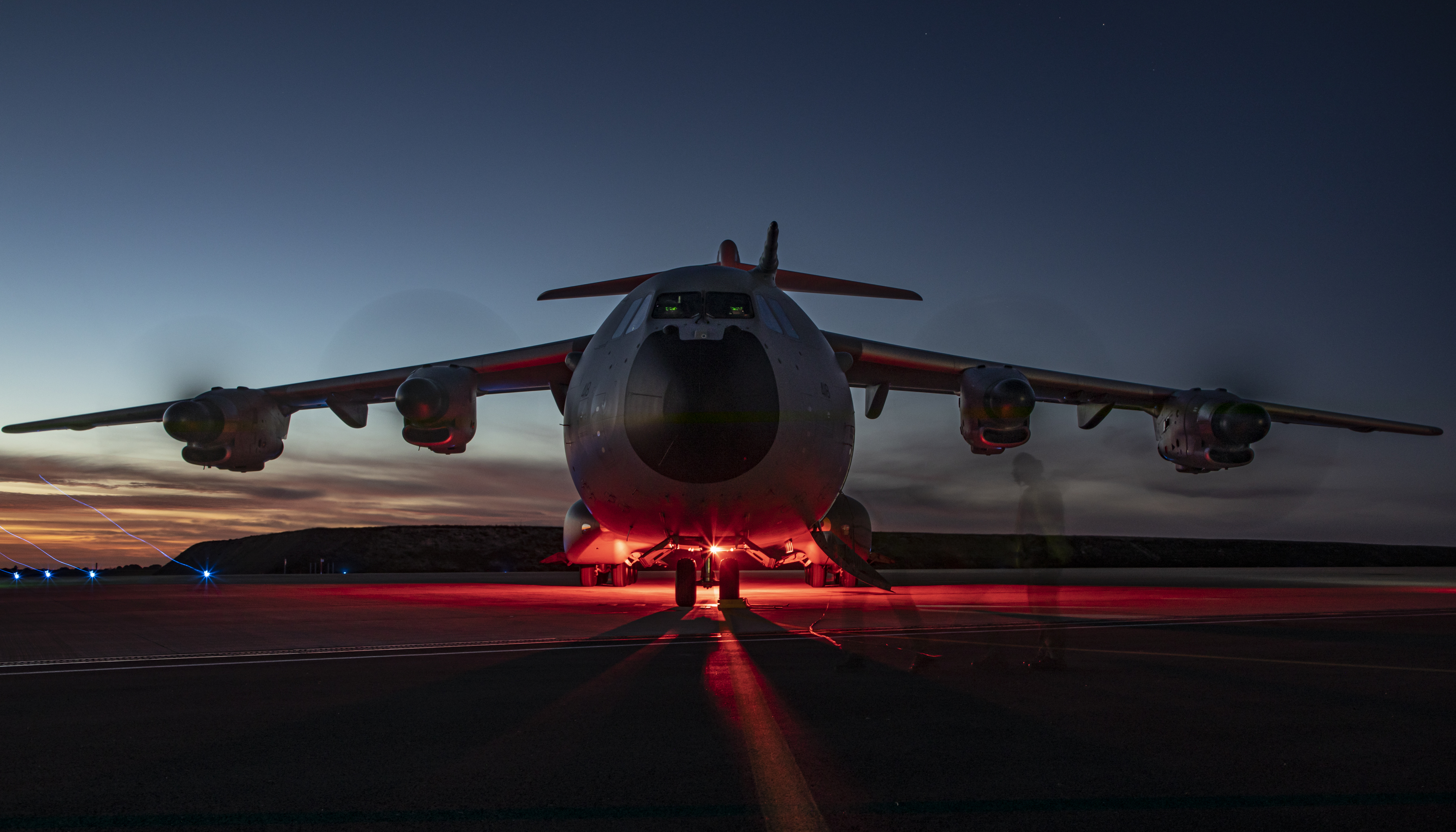 Image shows a RAF Atlas on the airfield with red lights underneath..
